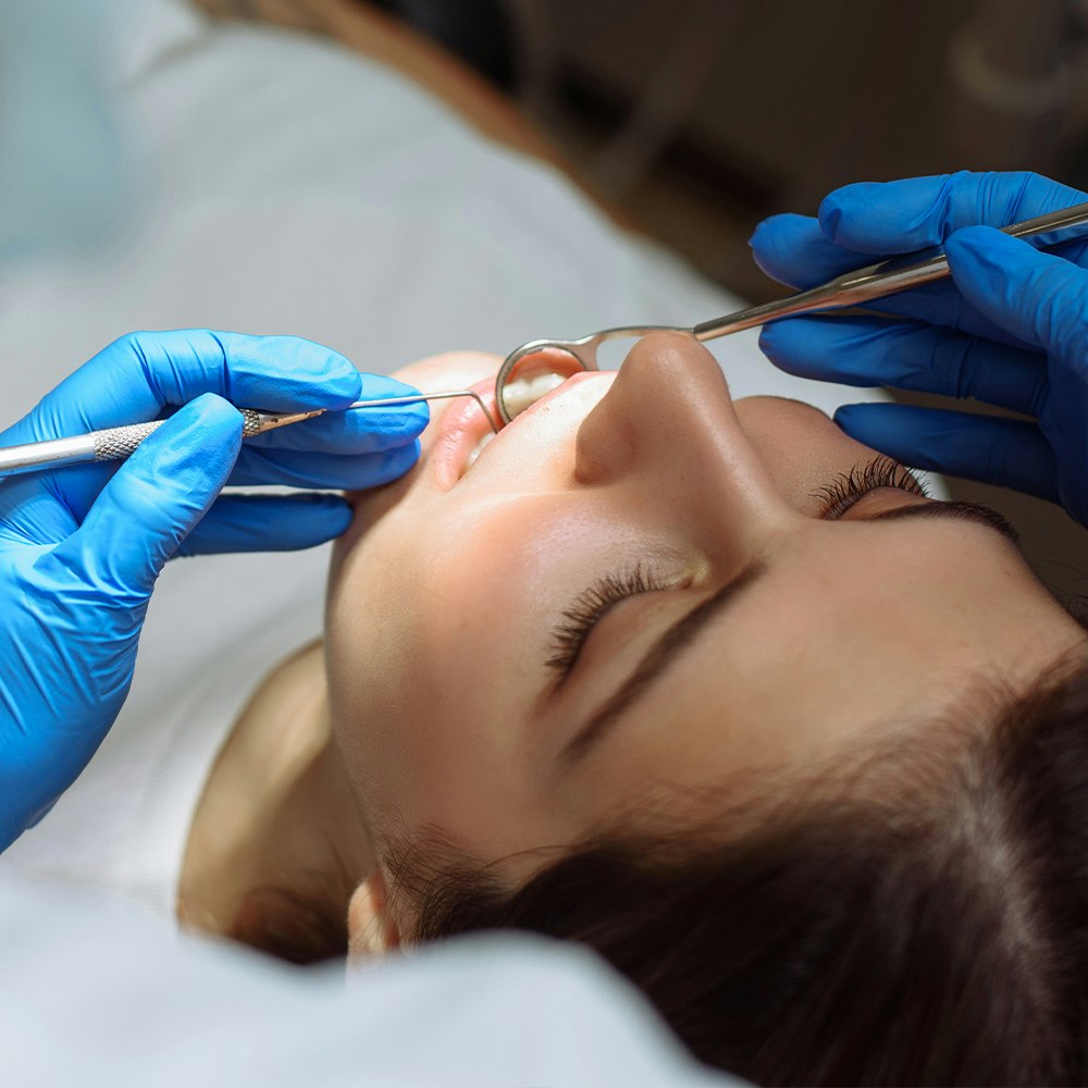 Woman under sedation getting dental treatment