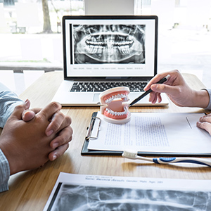Dentist using a model to educate their patient