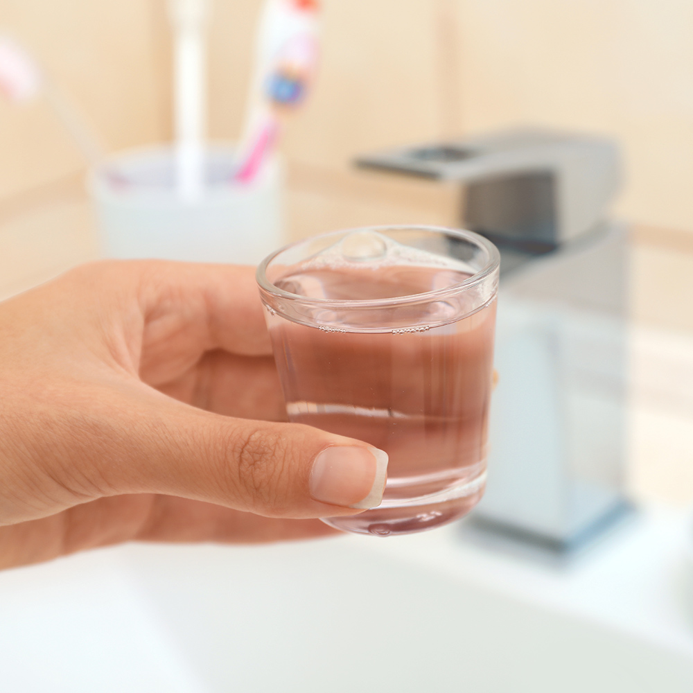 a hand with a cup of water in a bethroom