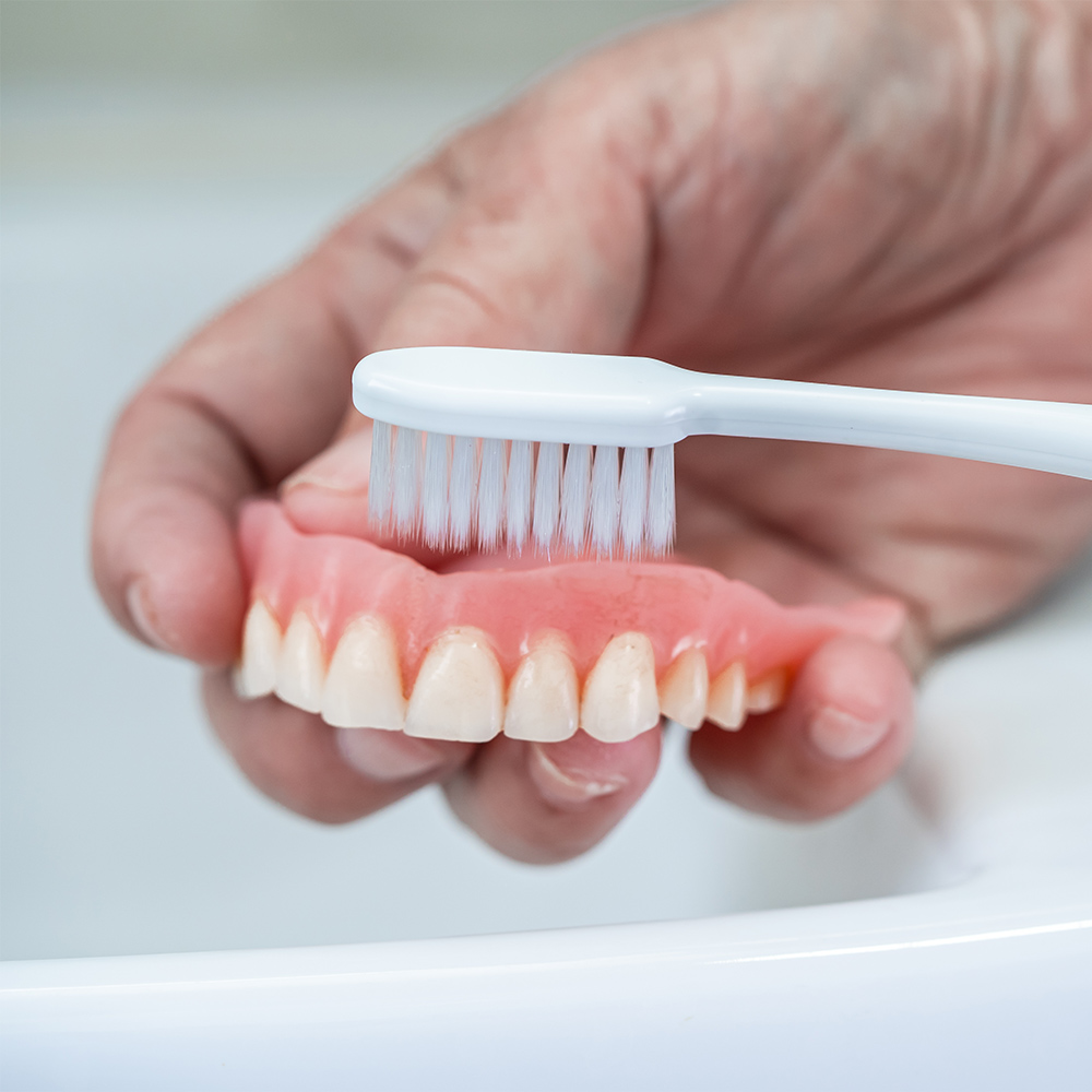 brushing dentures with a toothbrush