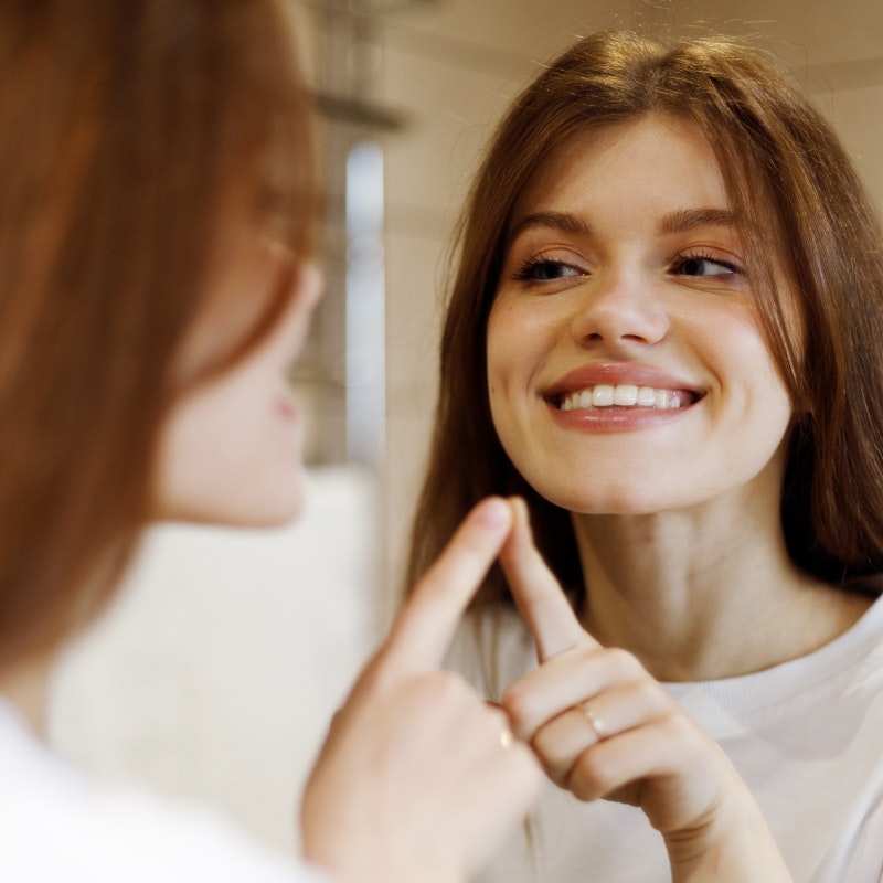 Smiling woman looking in mirror