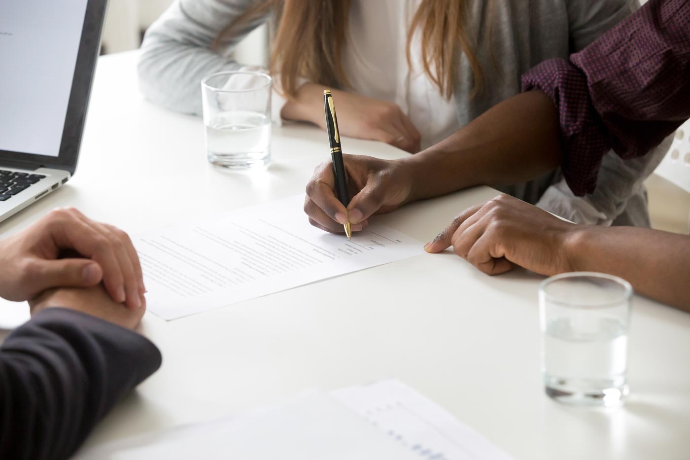 Couple talking and signing papers with lawyer