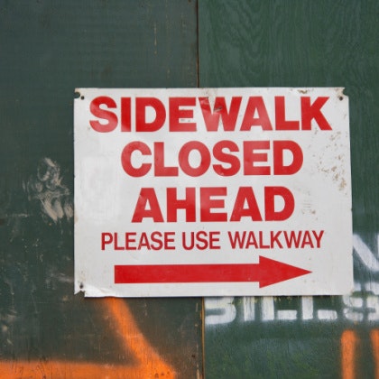 Sign reading Sidewalk closed ahead please use other walkway