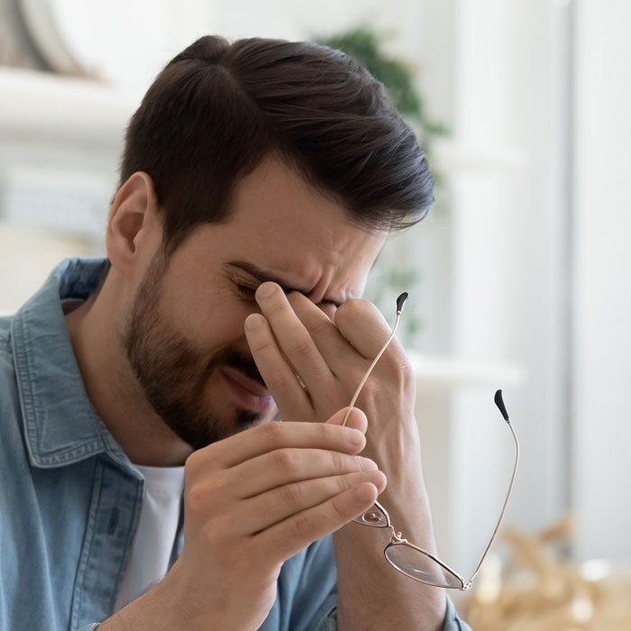 Man with rubbing his dry eyes