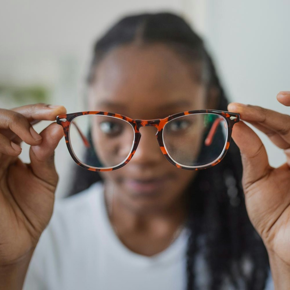 Woman holding glasses in front of her face