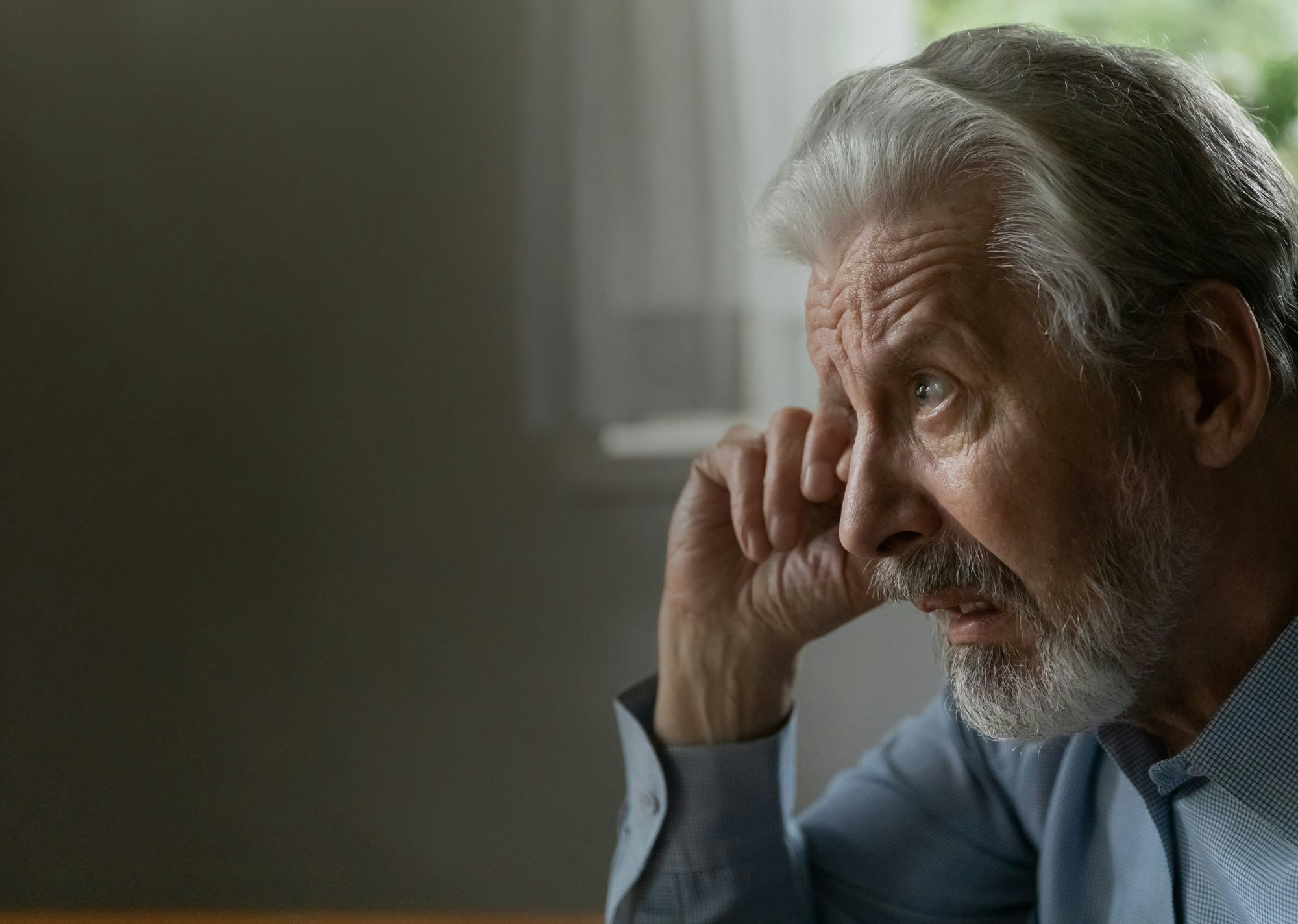 Older man rubbing eye