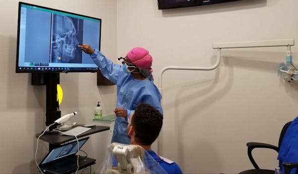 Dental team member looking at imaging with a patient