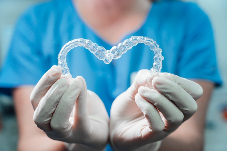 dentist holding invisalign aligners