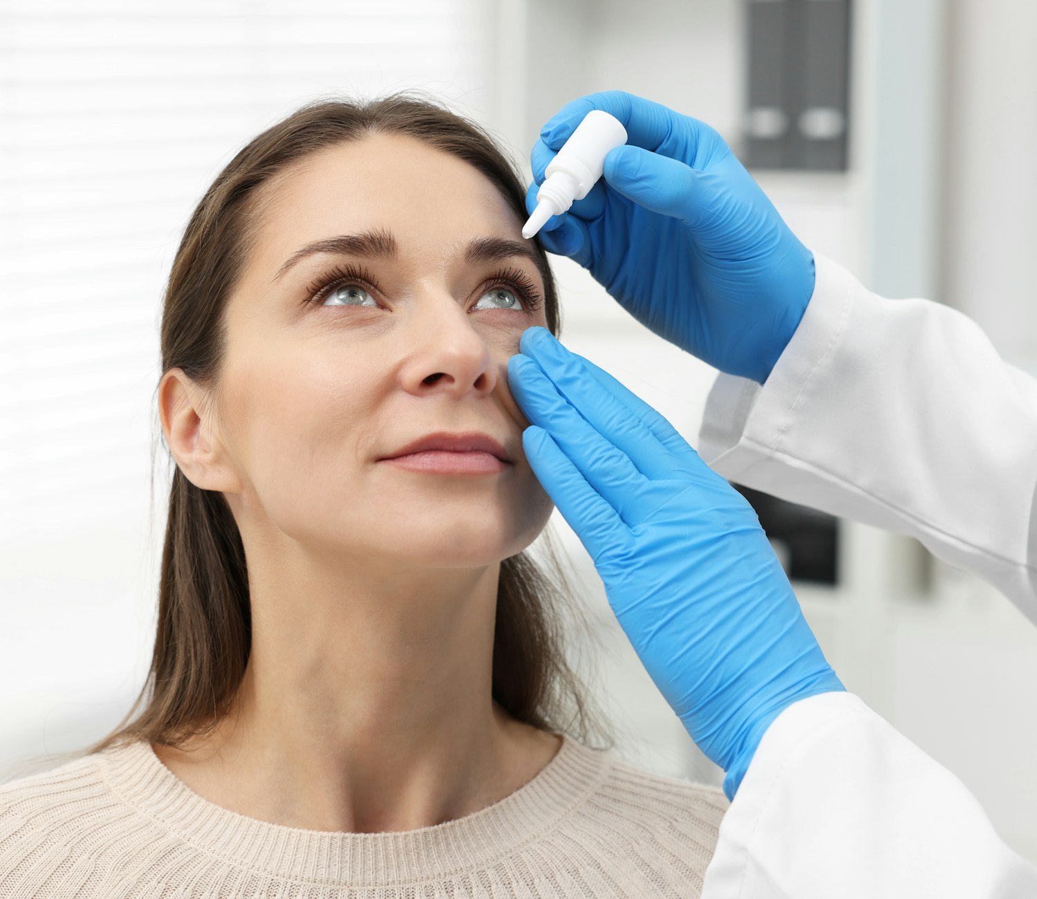 Doctor placing eye drops for patient