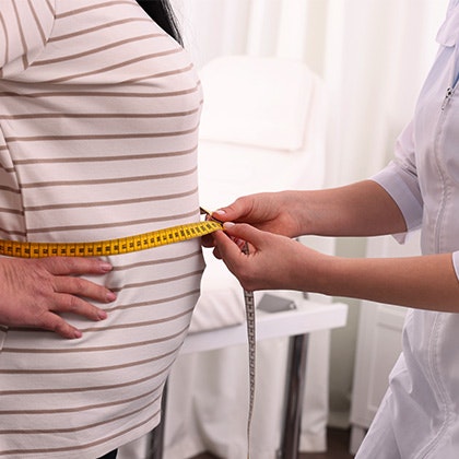 Doctor measuing patient's waist