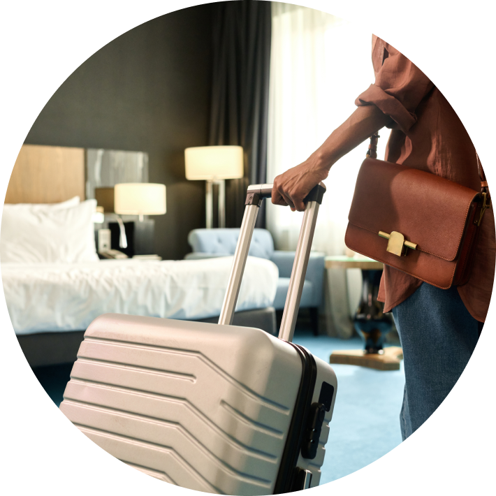Person walking with luggage into hotel room