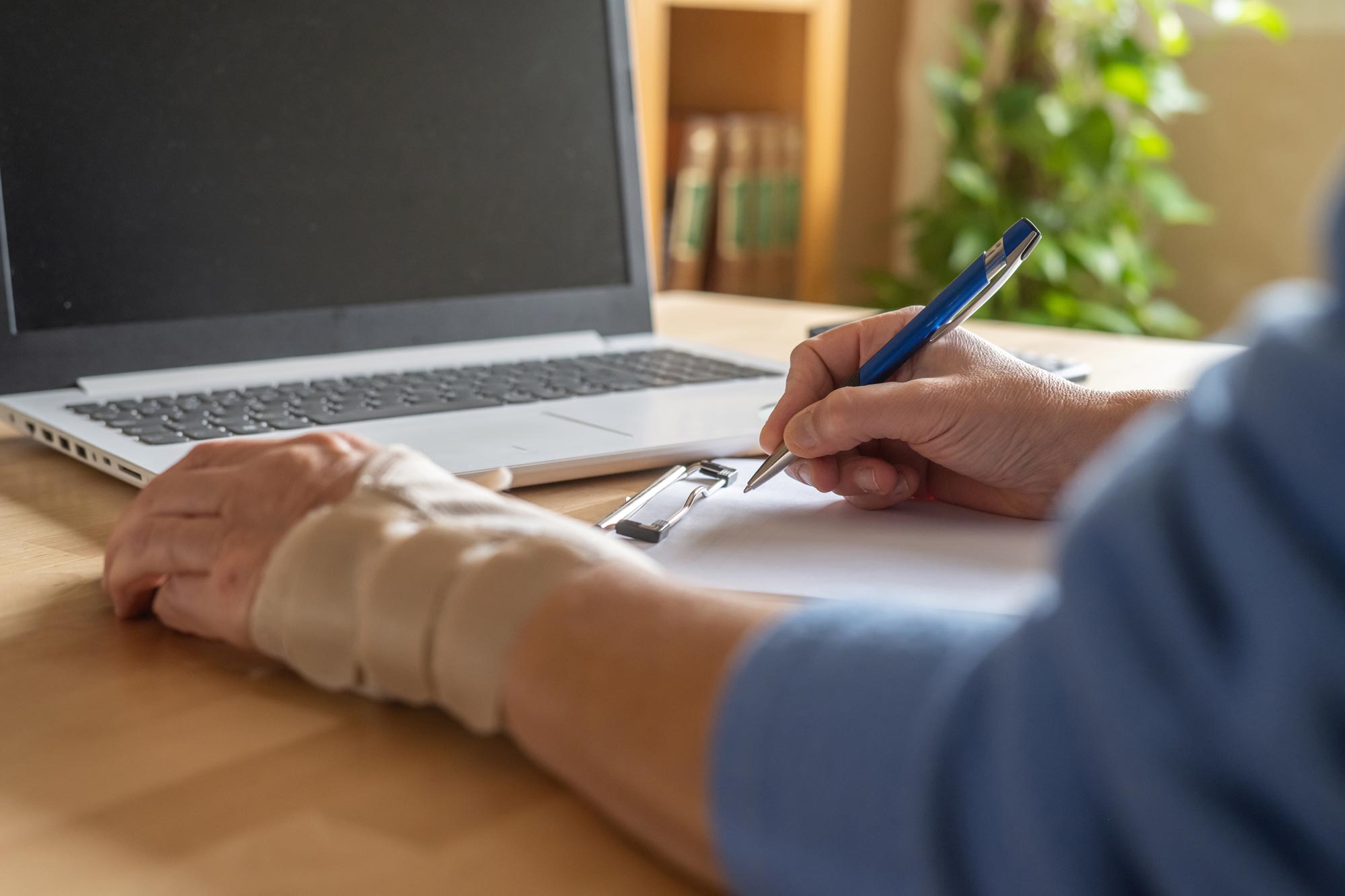 bandaged hand working at laptop