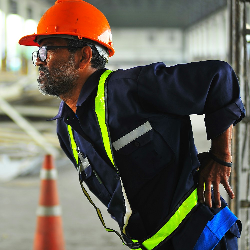 Construction worker holding back in pain