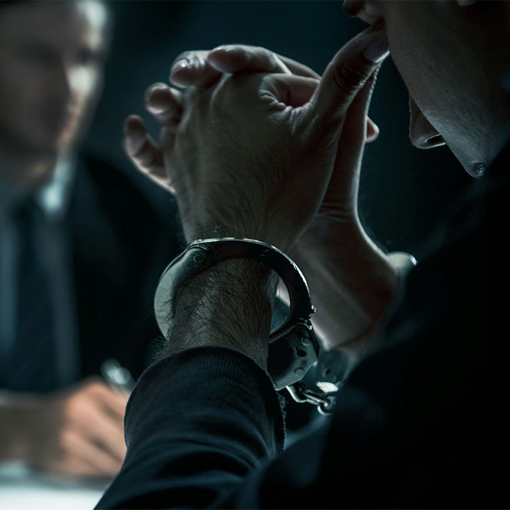 Man in handcuffs being interrogated