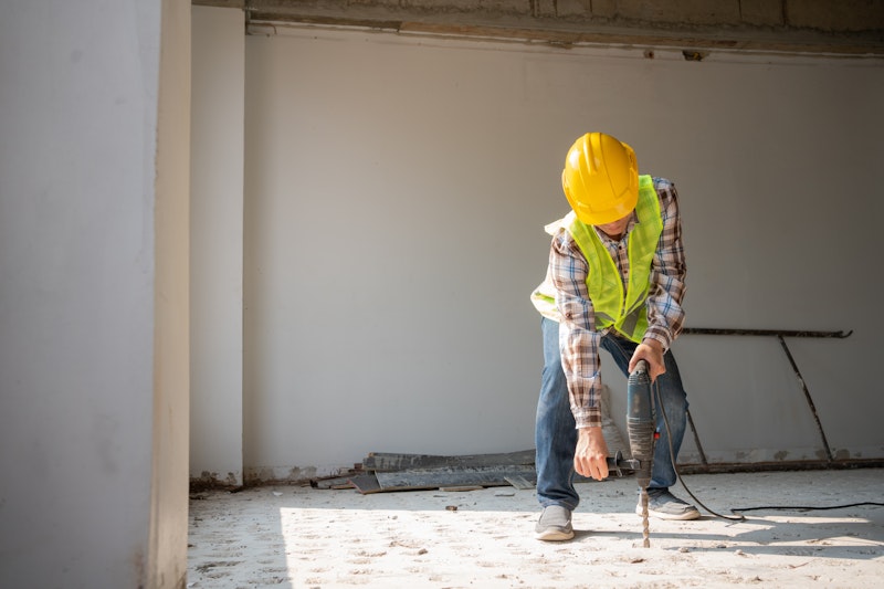 a construction worker making a hole in a floor