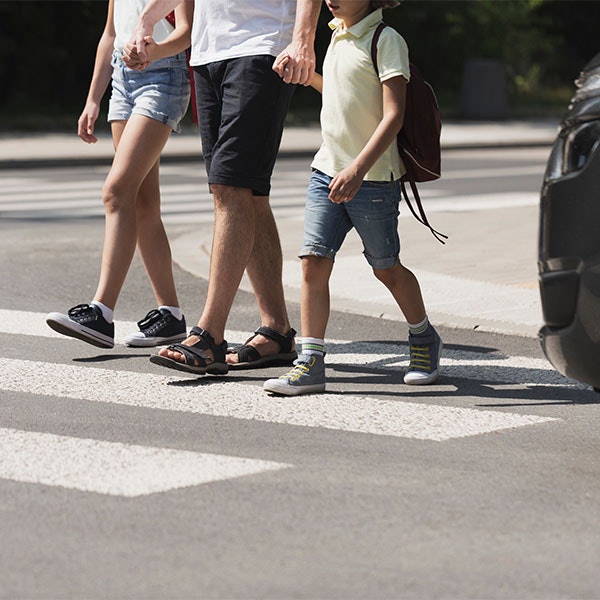 Pedestrians crossing crosswalk near vehicle