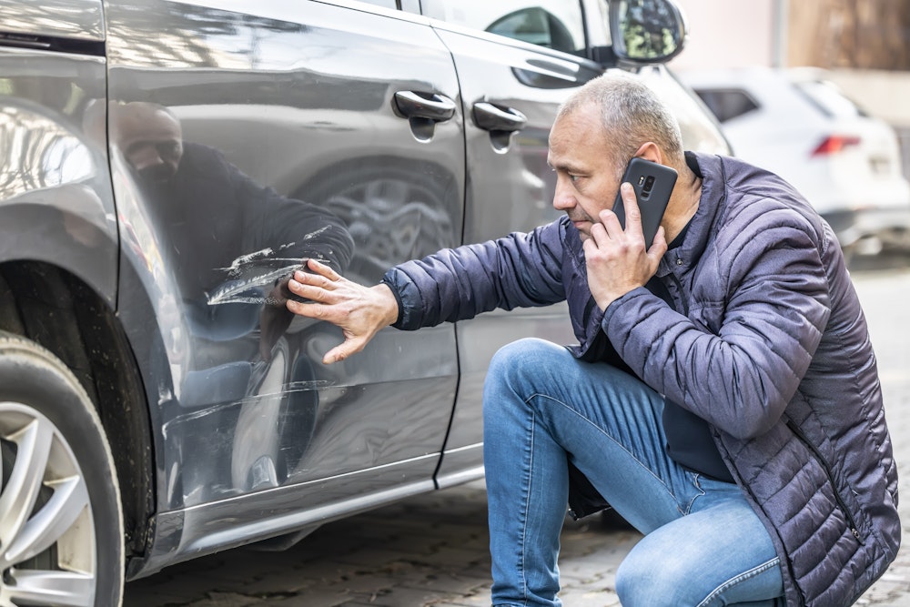 Man looking at his damaged car