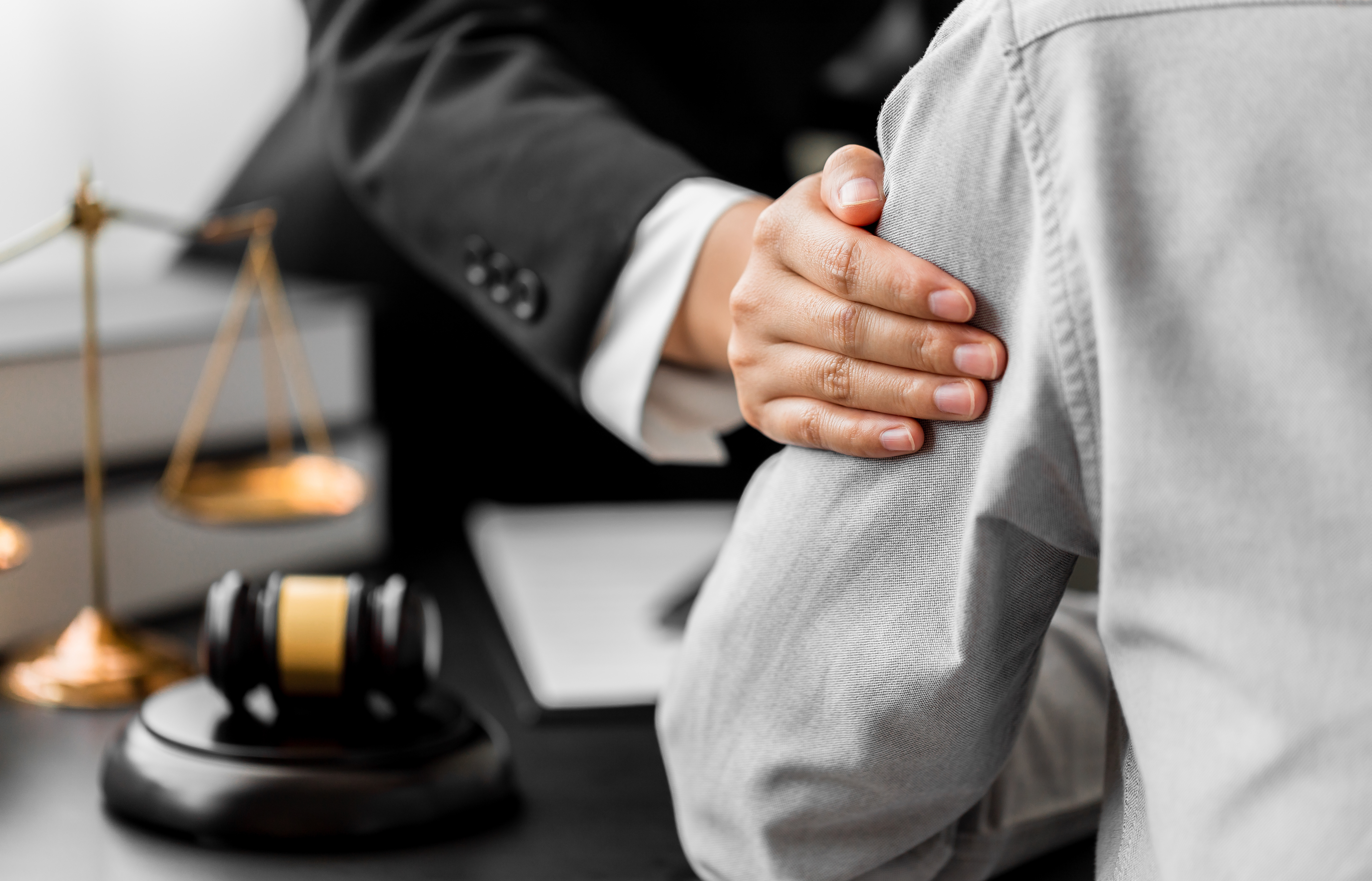 Attorney showing compassion by placing his hand on his client's shoulder