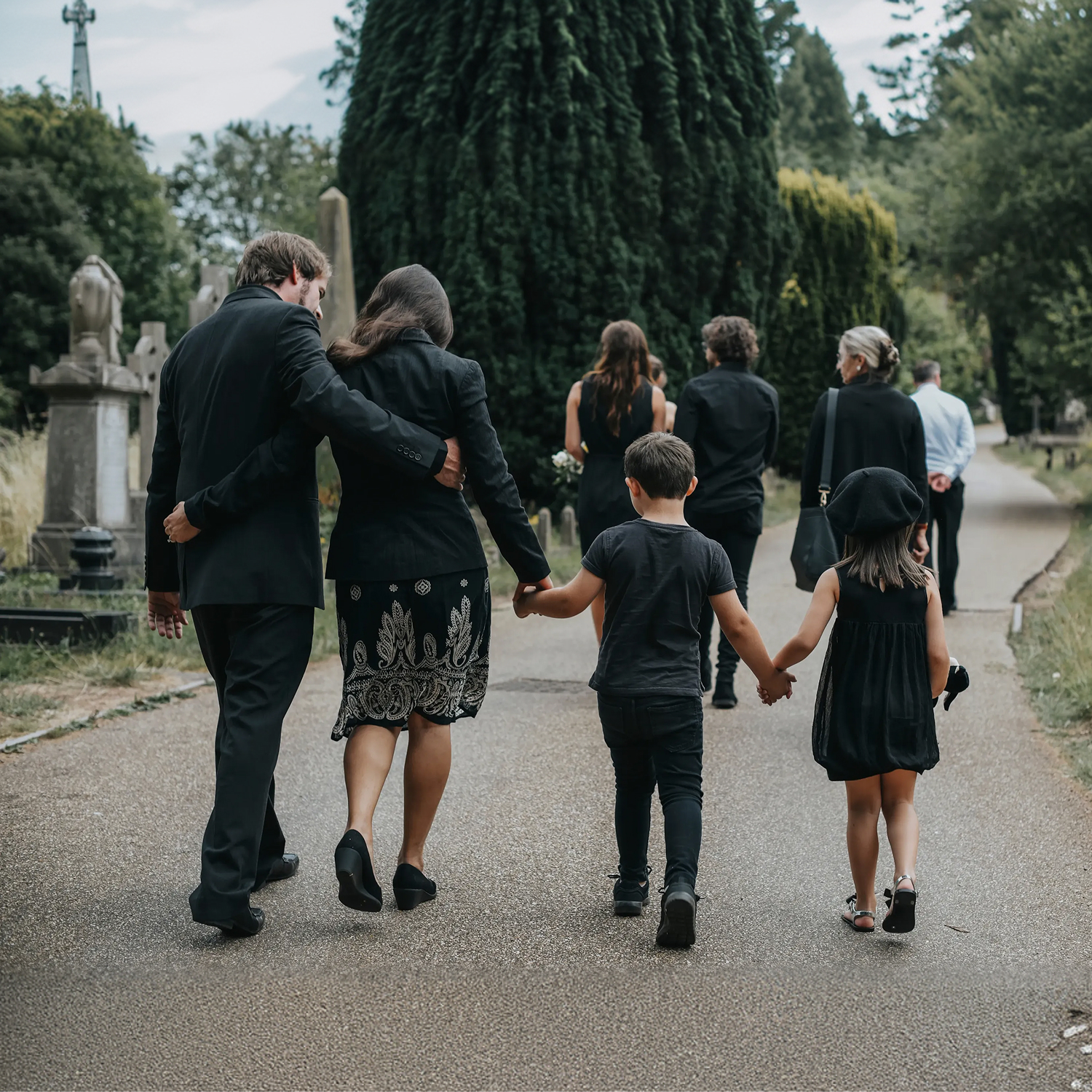 Grieving family walking through cemetery