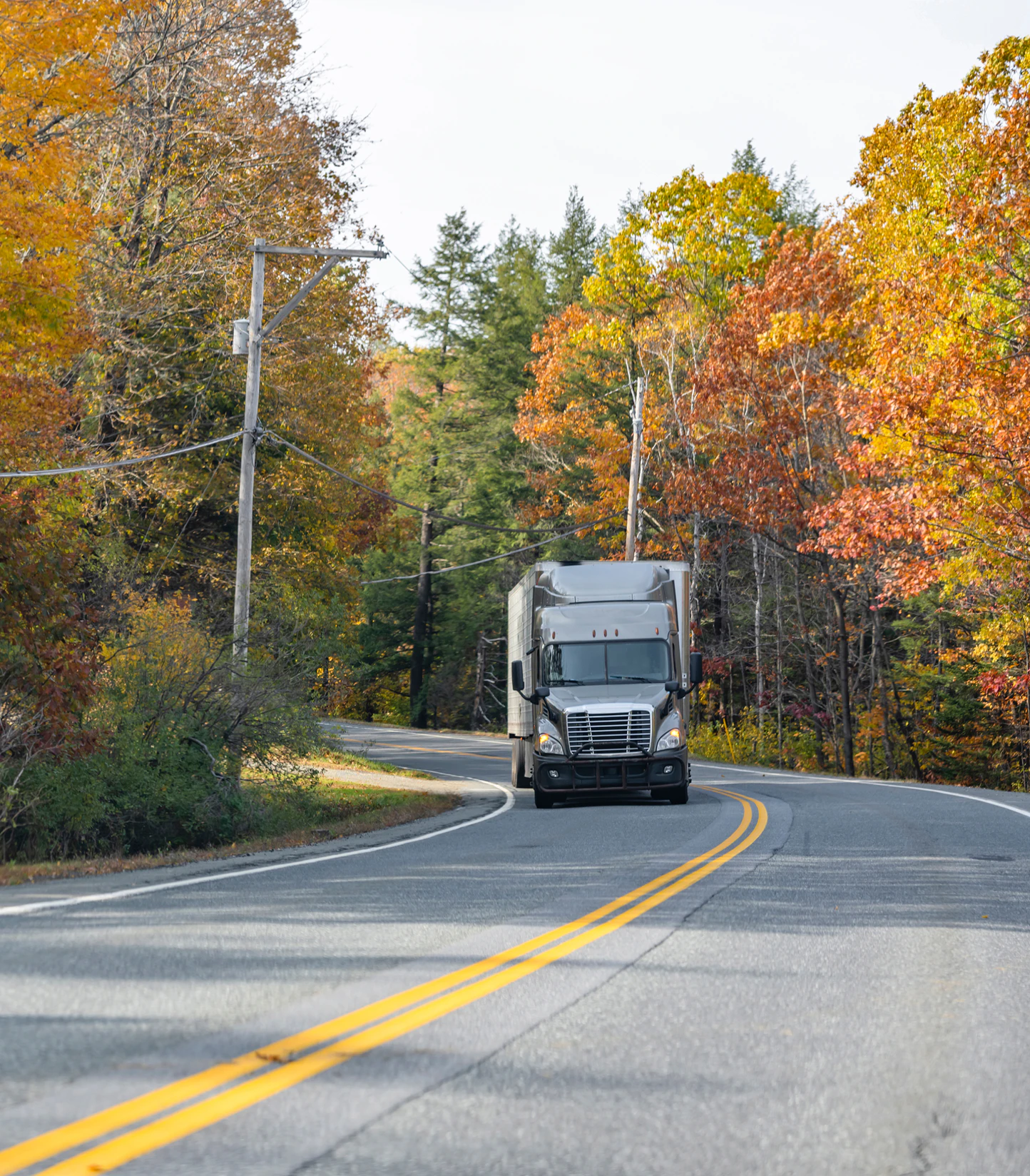 Truck driving through autumn leaves