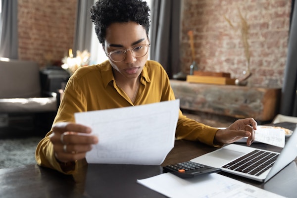 Woman looking at bills and a computer with a calculator
