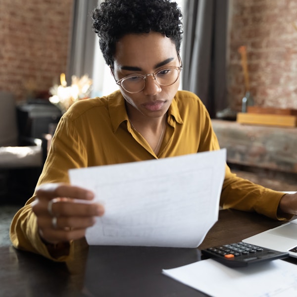 Woman looking at bills and a computer with a calculator