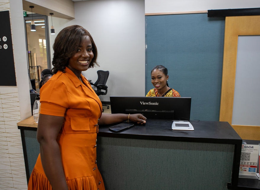 woman smiling behind desk