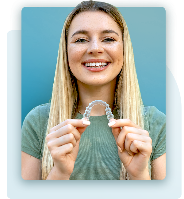 Smiling woman holding an Invisalign aligner