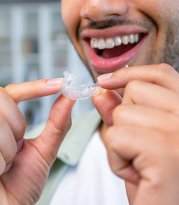 man putting in Invisalign aligner