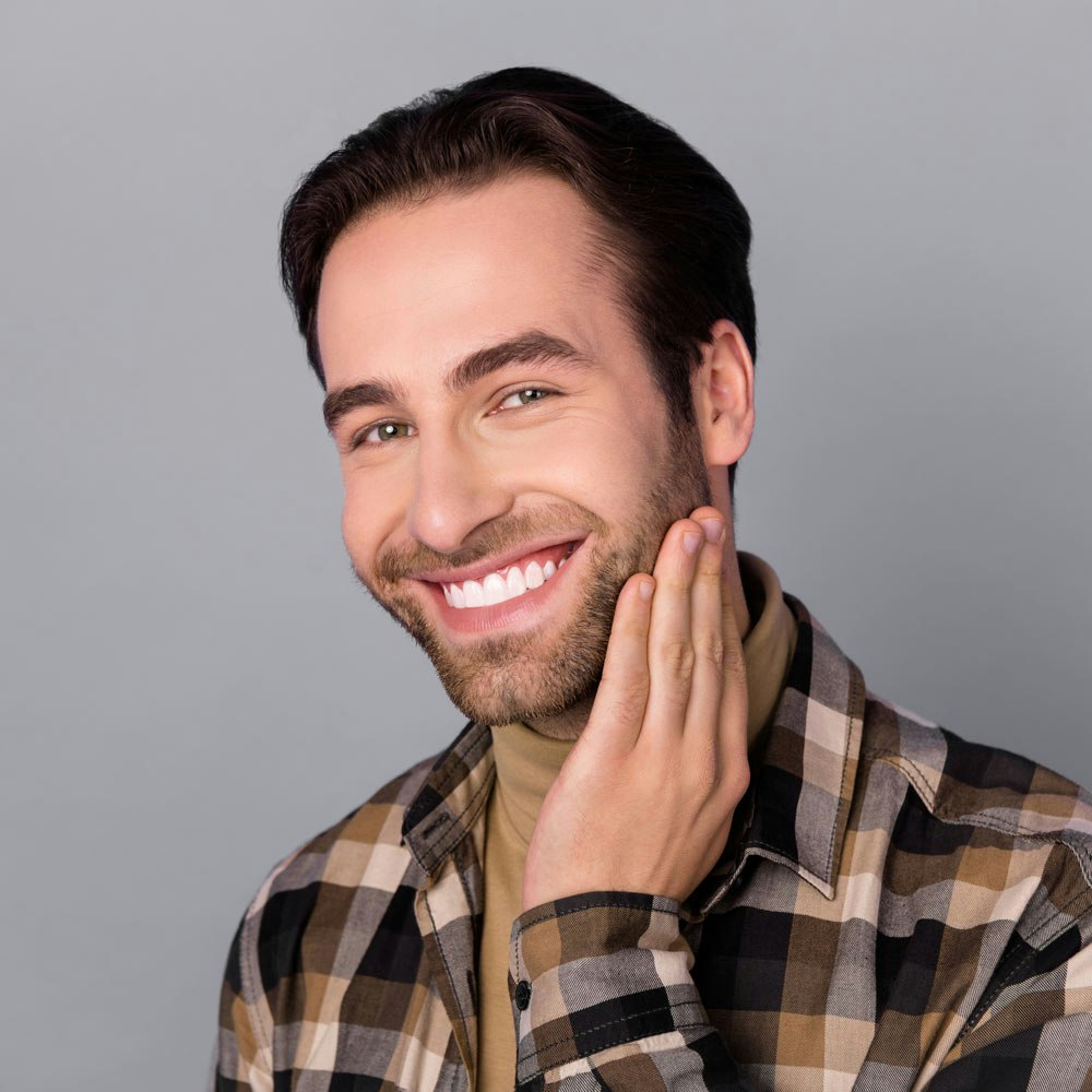 Smiling man touching cheek