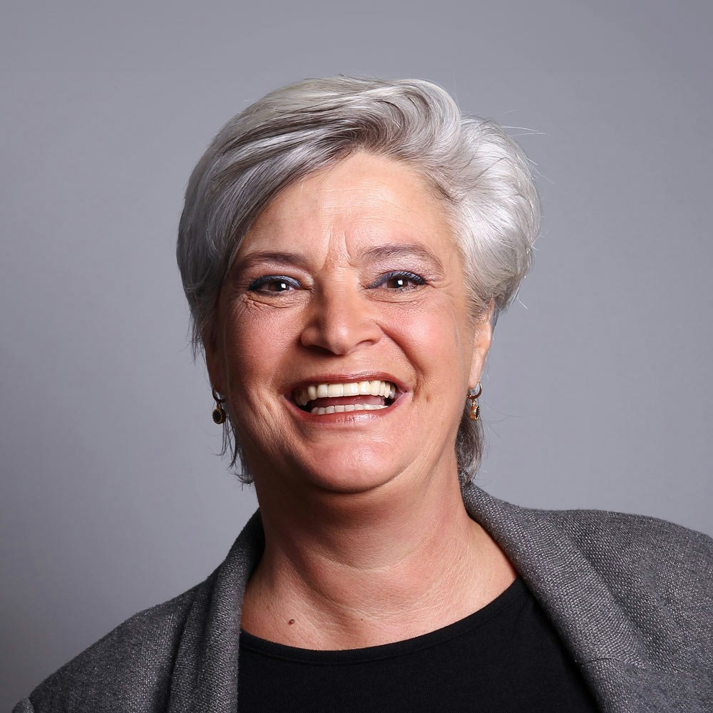 Mature woman smiling after dental crowns treatment