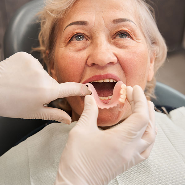 woman having partial dentures placed by a dentist