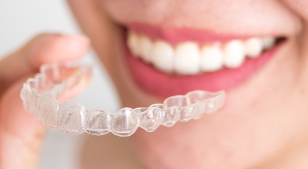 a woman holding an invisalign device