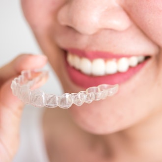 a woman holding an invisalign device