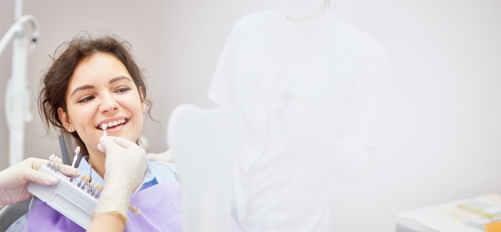 Veneer shade guide next to woman