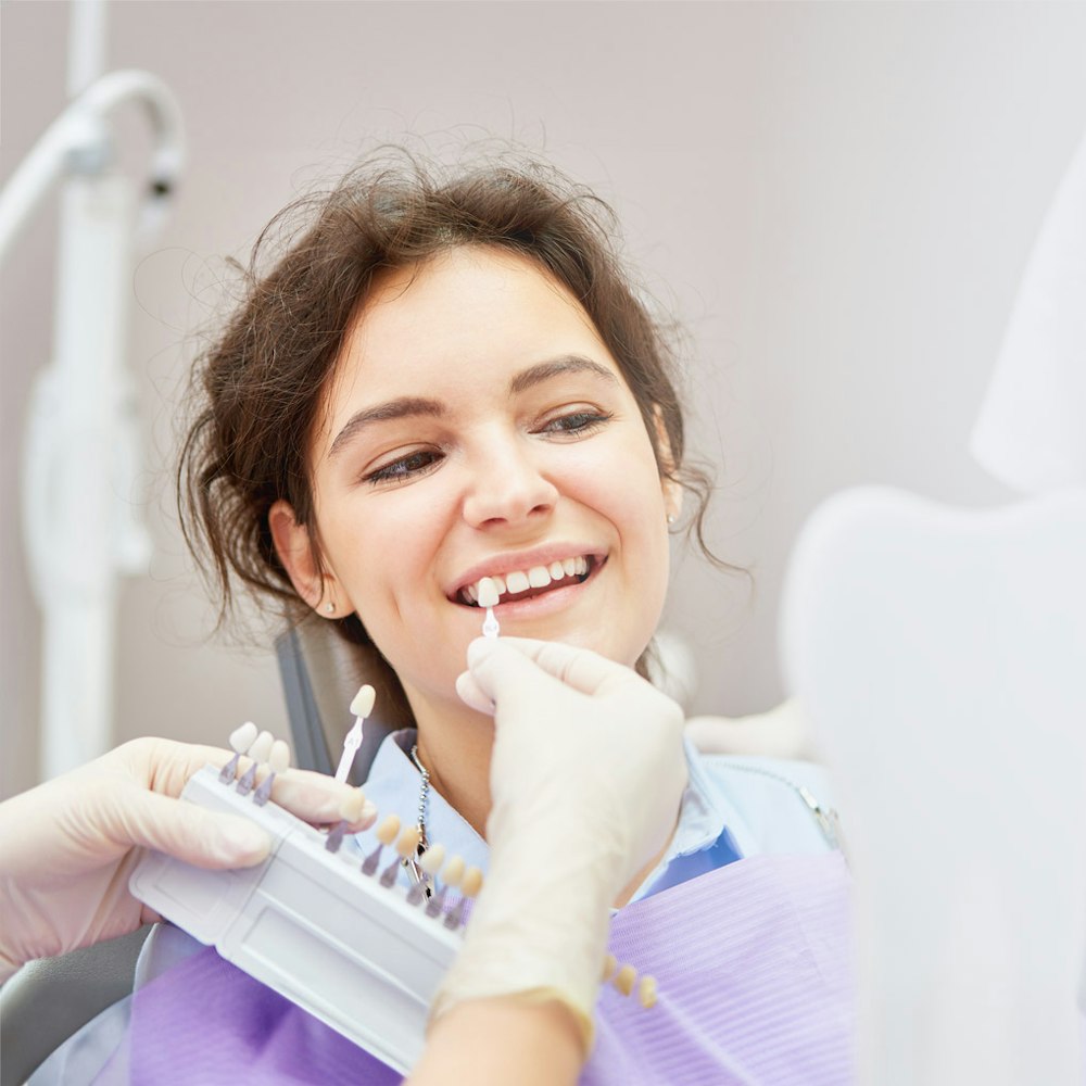Veneer shade guide next to woman