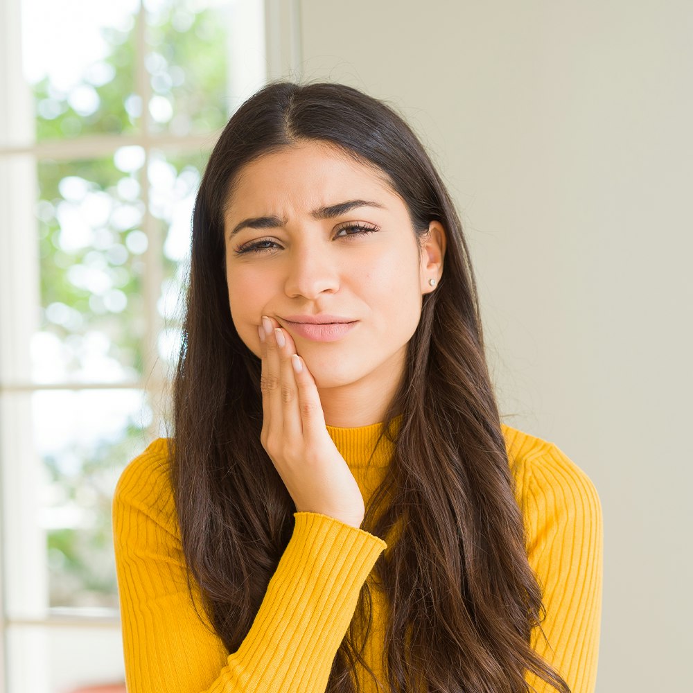 Woman holding jaw in pain