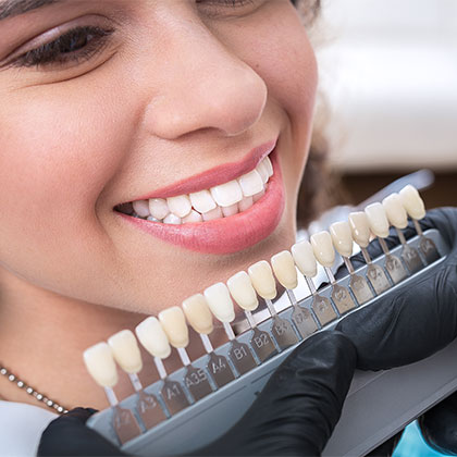 Dentist shade matching patient for veneers