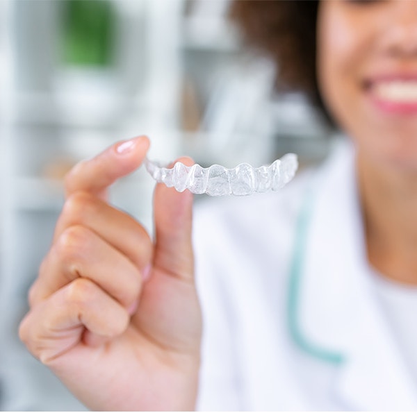 Woman holding an Invisalign tray