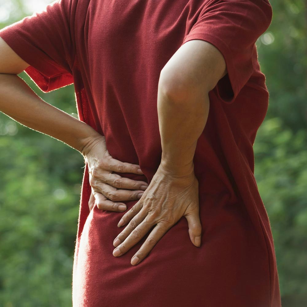 Person bracing hands against painful lower back