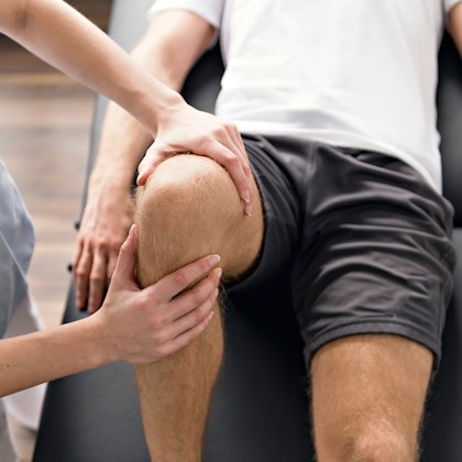 doctor examining patient's knee