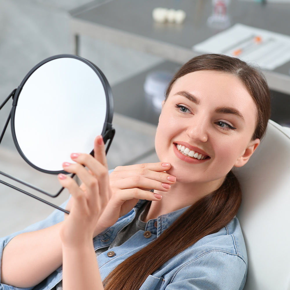 Excited dental patient looking in mirror