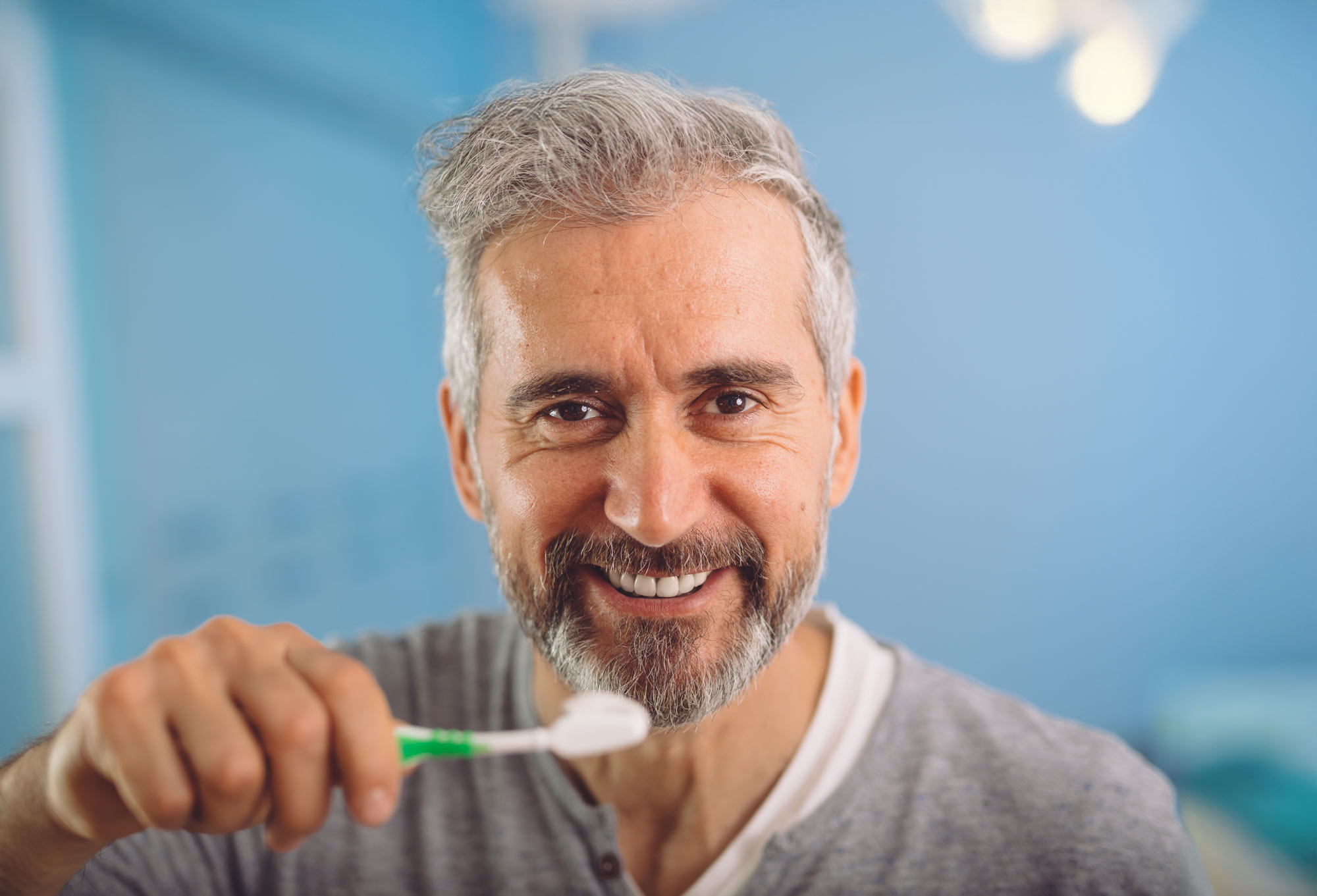 Happy man brushing his teeth