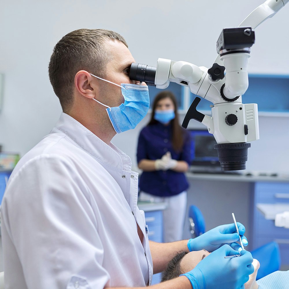 Dentist looking through microscope