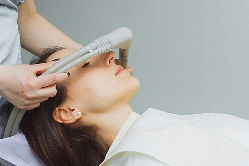 Dentist shade-matching veneers to a patients' smile