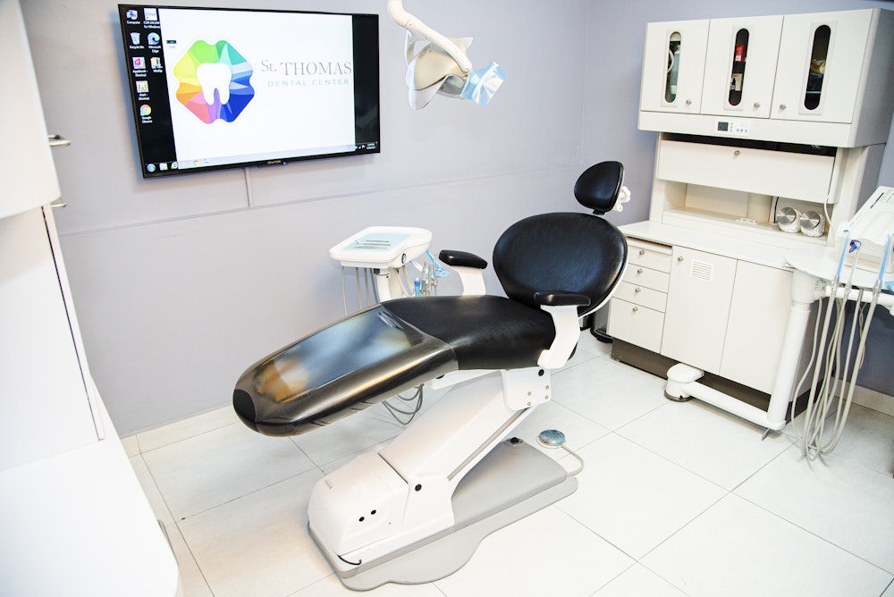 Dental chair with St. Thomas Dental Center big screen TV nearby