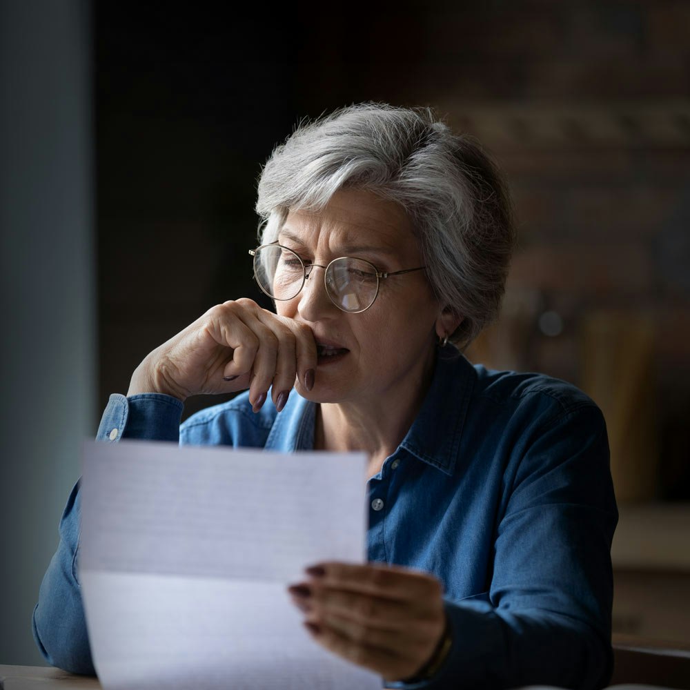 Mature woman looking at bankruptcy paperwork