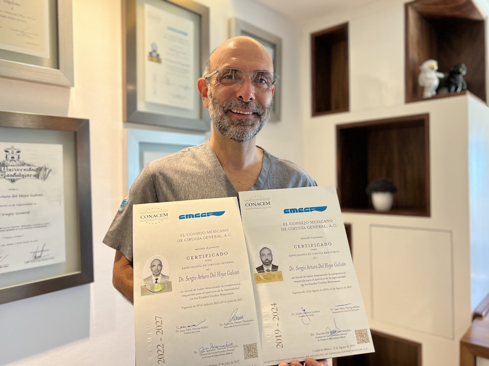 Dr. Del Hoyo in front of his awards carrying his 2019-2024 and 2022-2027 El Consejo Mexicano De Cirugía General, A.C. Certificado