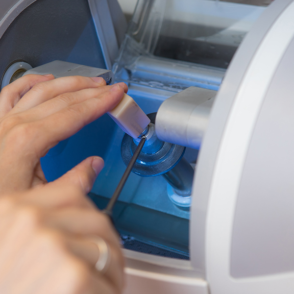 Dental professional placing porcelain block into a CEREC machine