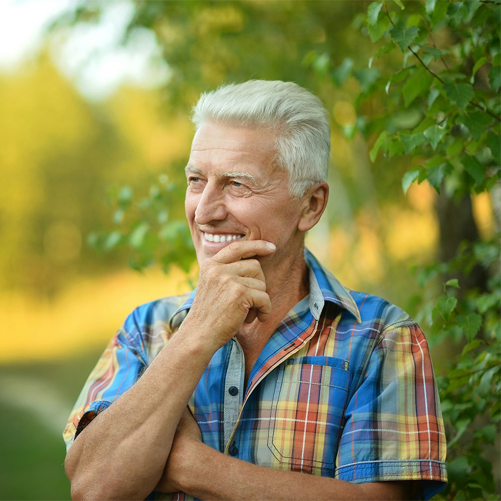 Older man smiling in a field